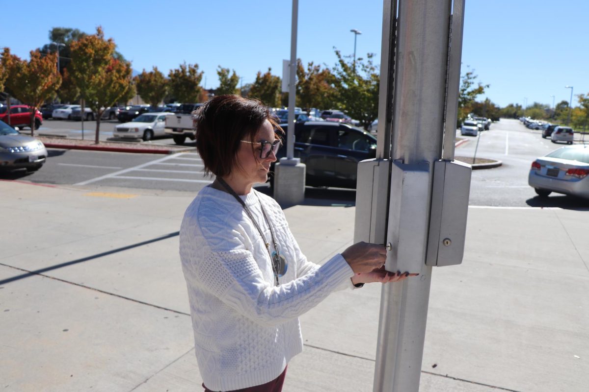 Ms. McMillan opens the flagpole’s Yonder pouch unlocking station